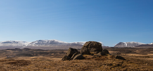 Icelandic landscape with snowy mountains and huge stones