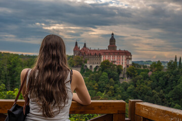 A young brunette looking at the Książ Castle in Silesia, Poland.