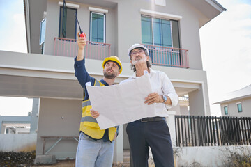 workers or architects holding plan blueprint paper and home inspection at construction site
