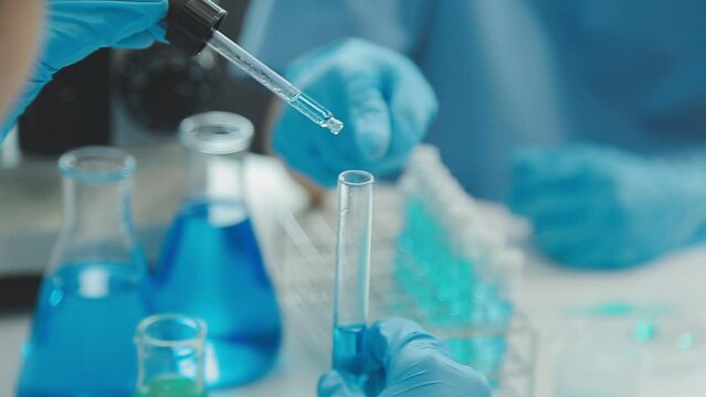 Doctor hand taking a blood sample tube from a rack with machines of analysis in the lab background, Technician holding blood tube test in the research laboratory.