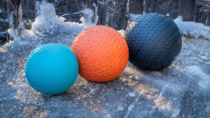 heavy slam balls filled with sand on an icy backyard deck, exercise and functional fitness concept