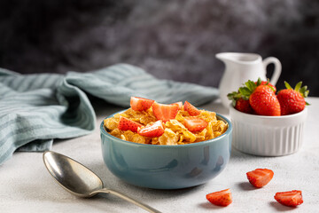Bowl of corn flakes with sliced strawberries.