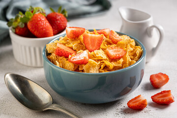 Bowl of corn flakes with sliced strawberries.