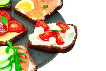 appetizing sandwiches in a gray plate on a white background. slices of bread with vegetables and meat in a plate on a light texture	