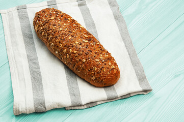 black sliced bread with bran on a white towel. oval dark bread on light texture	