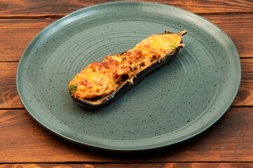 baked eggplant in a grey plate on a dark background. appetizing baked vegetable on a wooden table	