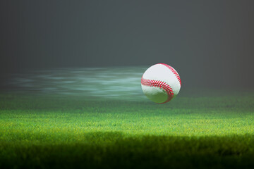 Baseball flying fast through the air in slow motion above the stadium grass