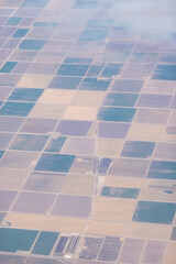 farm land from airplane looks like square tiles of brown and green