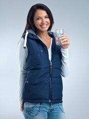 Woman in portrait, water for health and hydration in studio, nutrition and wellness with drink for thirst on grey background. Liquid, aqua and h2o in glass, fresh and clean for refreshment and detox