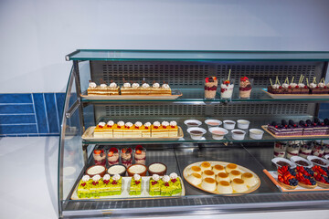 Close-up of shelves in restaurant with various types of sweet pastries. Curacao.