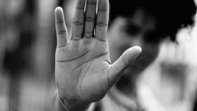 One Distressed African American Woman Signaling STOP with Raised Hand, Expressing Refusal, Dramatic Black and White NO Gesture