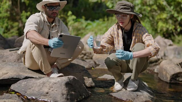 water day and World environment day concept.Environmental engineers inspect water quality at natural water sources and record data on tablet.Man engineer and Woman scientist and environmental issues
