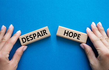 Despair or Hope symbol. Concept word Despair or Hope on wooden blocks. Businessman hand. Beautiful blue background. Business and Despair or Hope concept. Copy space