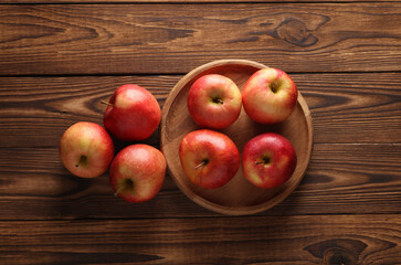 Plate with apples on a wooden table. To view