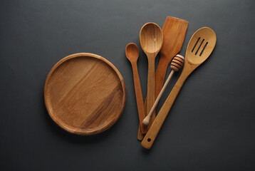 Wooden kitchen utensils on dark gray background. Top view