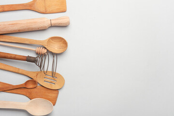 Set of wooden eco kitchen utensils on white background. Flat lay. Top view. Copy space