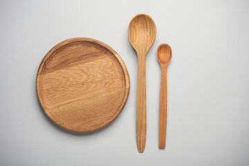 Wooden plate and spoons on white background