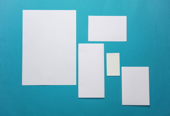 Mockup for design of white blank sheets of paper of different sizes and shapes, cards, envelope on blue background. Corporate identification. Creative layout