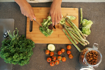Hands, knife and above for vegetables in kitchen with chopping, asparagus and cooking with...