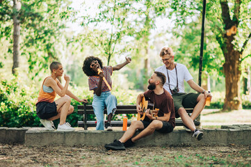 Four multiracial young adults are enjoying their time together making music.