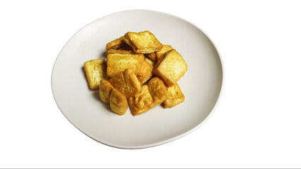 Fried tofu on a plate isolated on white background, yellow tofu or takwa tofu on a dining plate.