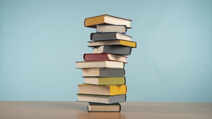 Colorful Pile of Books Against a Pastel Blue Background