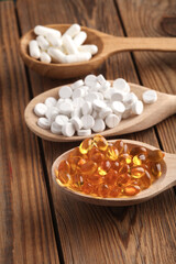 Various pills in wooden spoons. Medicine concept