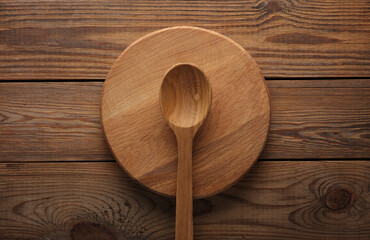Wooden spoon with plate on the table. Top view