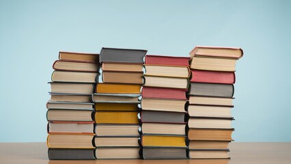 Colorful Piles of Books Against a Pastel Blue Background