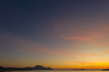 aerial view scenery yellow sky over the island at sunrise..beautiful sky of sunrise at Rawai beach Phuket Thailand.image for travel concept. cloud in sky background..