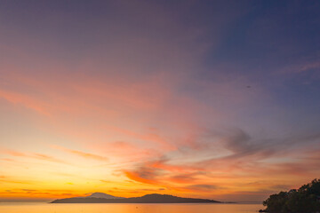 aerial view scenery yellow sky over the island at sunrise..beautiful sky of sunrise at Rawai beach Phuket Thailand.image for travel concept. cloud in sky background..