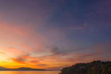 aerial view scenery yellow sky over the island at sunrise..beautiful sky of sunrise at Rawai beach Phuket Thailand.image for travel concept. cloud in sky background..