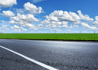 Fototapeta premium abstract empty road in summer, blue sky, white clouds, highway or speedway in rural countryside created with generative ai technology