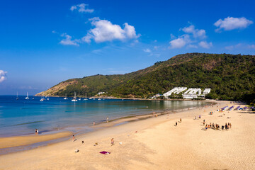 aerial view white beach, blue and green sea at Nai Harn beach. .Nai Harn beach is a famous landmark and popular viewpoint of Phuket Thailand..smooth waves hit the rock at foot hill.