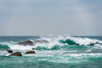 Le ressac caresse les pierres immergées tandis que les eaux turquoise ourlent le littoral breton d'une beauté saisissante, révélant toute la splendeur de la côte.