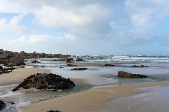 Plage de sable et rochers bretons révélés à marée basse dans le Finistère nord