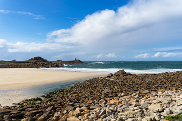 Fototapeta na wymiar Plage bretonne bordée de rochers découverts à marée basse
