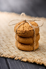 Oatmeal cookies tied with a rope on a wooden table. The concept of food for breakfast