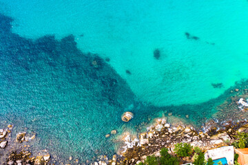 aerial view waves crashing on the rock beside the beach..white bubble waves in turquoise sea on the rock. .creative nature and travel concept.