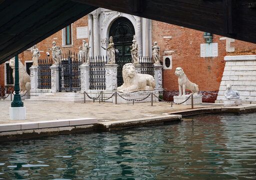 Venice, Italy–Sept. 18, 2023: Four ancient marble lion statues stand guard at the Venetian Arsenal, the city’s old armory, shipyard and military headquarters for centuries.