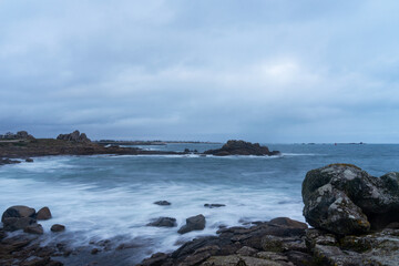 Pose longue capturant la tranquillité de la mer depuis une plage du littoral breton.