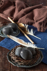 Wine painted eggs in a nest, bird feathers, drapery on a wooden background. Easter concept. - 753243996