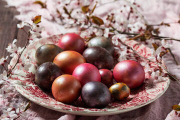 Eggs painted in different colors and covered with mother-of-pearl, and blossoming plum branches. Easter concept. - 753244184