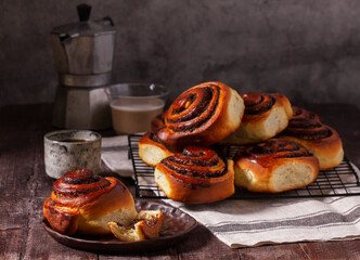 Yeast dough cinnabons with poppy seeds, raisins and candied fruits, served with coffee. Rustic style. - 753244709