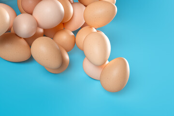 Vibrant Blue Background Showcasing a Collection of Natural Brown Eggs