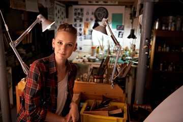 Artist, studio and portrait of woman in workshop for creative sculpture or project at night. Artisan, workplace or person with pride or confidence as carpenter with talent for working with tools