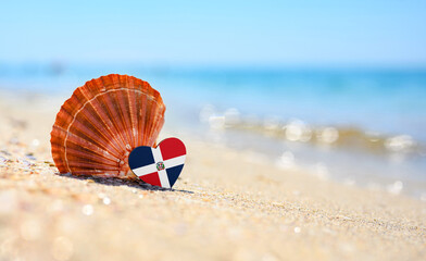 Obraz premium Sandy beach in Dominican Republic. Dominican Republic flag in the shape of a heart and a large shell. A wonderful resort on the Caribbean Sea