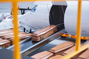Aircraft Conveyor Loading Wooden Coffins for Solemn Journey - obrazy, fototapety, plakaty