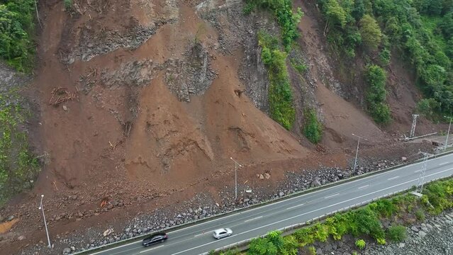Mountain soil collapse in half of the highway. Landslides due to heavy rainfall. Rockslide over road. Dangerous Landslide, natural disaster led to roadblock. Climate change, warming, desertification