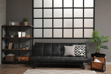 Stylish interior of modern living room with black sofa